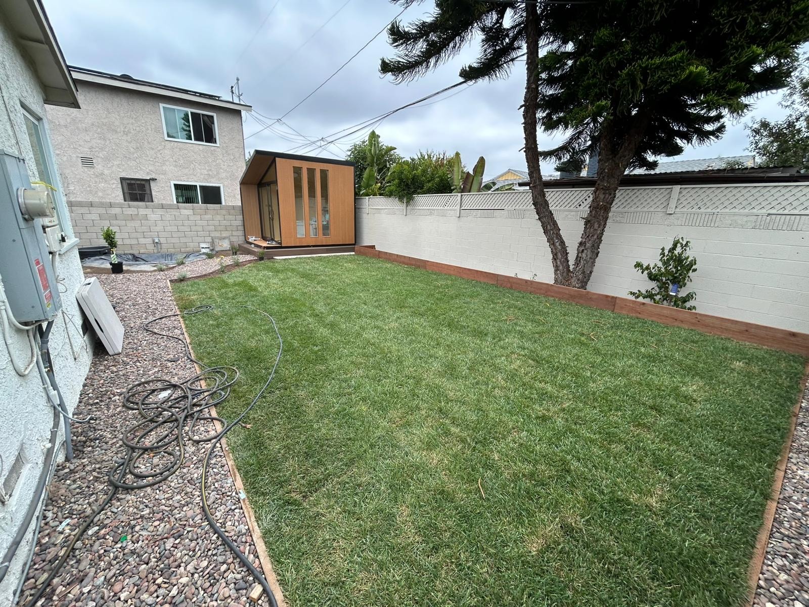 Backyard project with modern shed structure and freshly landscaped lawn