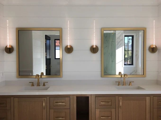 Luxury bathroom vanity with brass faucets and gold-framed mirrors